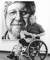 Artist Phil Spaziani in front of portrait of Phil Spaziani by former student Stephen Bennett as photographed by Leif Zurmuhlen